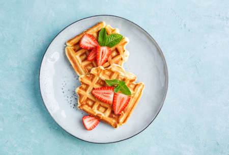 Homemade belgian waffles with strawberries, top view. Delicious Breakfastの写真素材