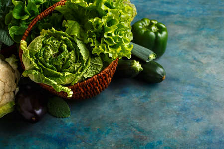 Fresh green lettuce, cabbage and vegetables in a basket. Food background with copy pace for your text.の写真素材