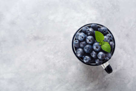 Fresh blueberries in a cup on a light marble background with copy space. Freshly picked blueberriesの写真素材