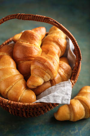 Freshly baked croissants in a wicker basket, Selective focusの写真素材