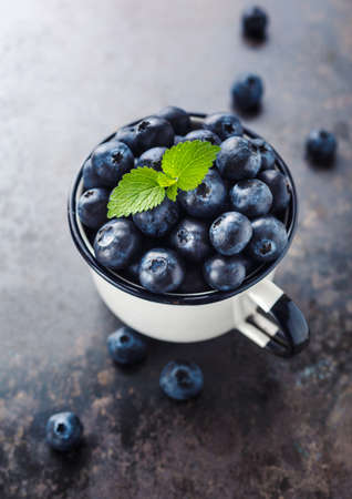 Raw organic healthy blueberries in a cup with mint. Freshly picked blueberries. Selective focus.の写真素材