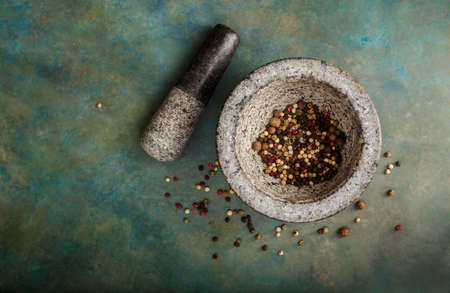 Pepper spice mix in a mortar on a green background, selective focusの写真素材