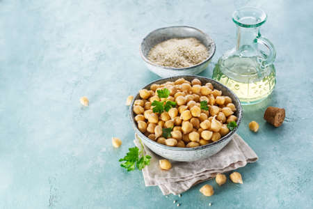 Ingredients for cooking hummus. Chickpeas, sesame seeds and oil. Food background with copy space for your text.の写真素材