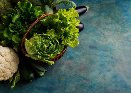 Fresh green lettuce, cabbage and vegetables in a basket. Organic healthy vegetables. Food background with copy space.の写真素材