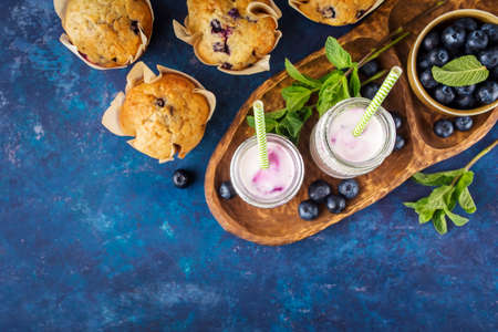 Homemade muffins with blueberries and yogurt with mint. Food background with copy space. Top view. Selective focus.の写真素材