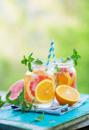 Water detox with Grapefruit and Orange in Jars, Outdoor. Refreshing summer drink. Copy space.の写真素材