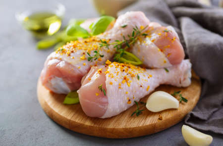 Fresh raw chicken legs with spices - salt, pepper, olive oil and garlic. Close upの写真素材