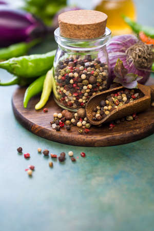 Pepper spice mix in a glass jar and fresh garlic, ingredients for cooking. Selective focus. Food background with copy space.の写真素材