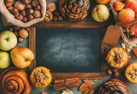 Freshly baked pumpkin muffins and cinnamon rolls and ingredients for baking.の写真素材