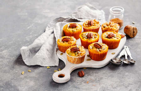 Freshly baked pumpkin muffins with pecans, selective focus.の写真素材