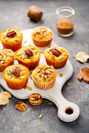 Freshly baked pumpkin muffins with pecans.の写真素材