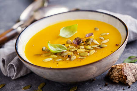 Pumpkin soup with basil leaf and spice, close up.の写真素材