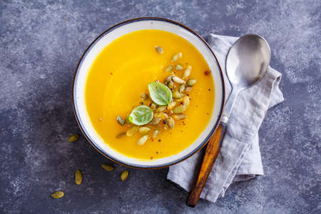 Tasty Pumpkin Soup with basil leaf and pumpkin seeds, Top view.の写真素材