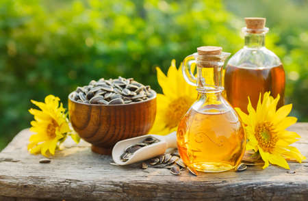 Sunflower oil with flowers and seeds on old table. Outdoorsの写真素材