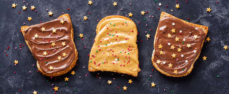 Three toasts with chocolate and peanut cream and sprinkles.の写真素材