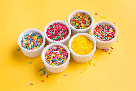 Confectionery sprinkles on a yellow backgroundの写真素材