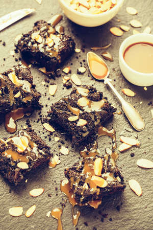 Pieces of chocolate cake with caramel and almond flakesの写真素材