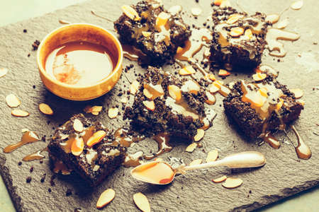Cake pieces with caramel on the stone background decorated with almond flakes. Selective focus.の写真素材
