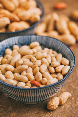 Peeled peanuts in bowls close-up, selective focus.の写真素材