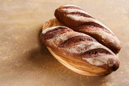 Freshly baked bread on a wooden cutting board. Food background with copy space.の写真素材