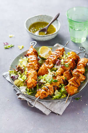 Chicken skewers with lime and mint and spicy sauce.の写真素材