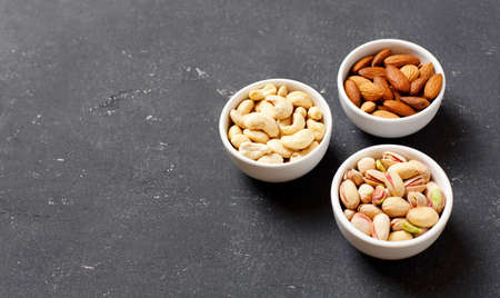 Organic nuts, almonds, cashew, pistachio in a bowls, delicious snack. Close up Copy spaceの写真素材