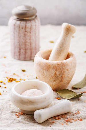 Himalayan pink salt and spices in marble mortars, selective focus.の写真素材