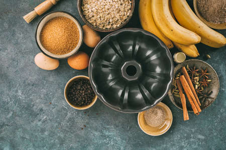 Cake pan with ingredients for baking, flour, butter, sugar, eggs and spices.