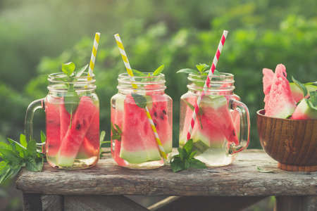 Fresh watermelon beverages in glass jars in the garden. Toned image.の写真素材