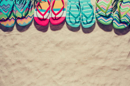 Colorful beach Slippers on the clean sand. Summer background with copy spaceの写真素材