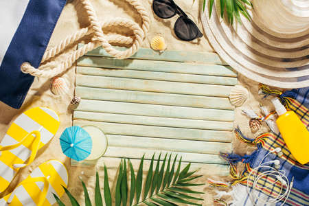 Hat, beach bag, sun glasses and glass of coconut water on a beach. Summer vacation background with copy space. Top view.の写真素材