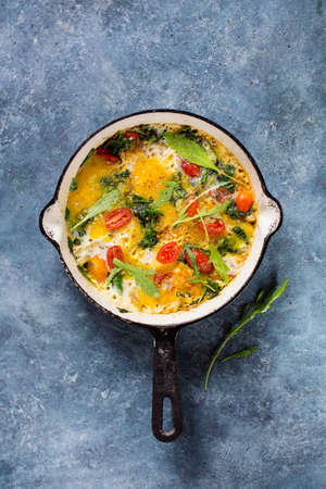 Scrambled eggs with spinach and tomatoes, top view.の写真素材