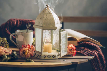 Autumn still life with a Cup of tea, a book and an extinct lantern.の写真素材