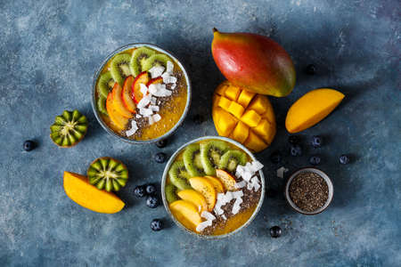 Mango smoothie bowl with kiwi, peach and chia. Healthy vegan diet breakfast concept.の写真素材
