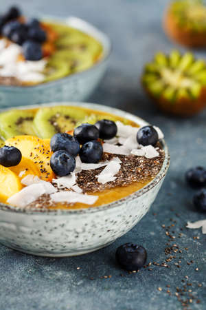 Freshly blended fruit smoothie with chia seeds, coconut flakes, kiwi and blueberries. Healthy breakfast.の写真素材