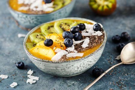 Fruit smoothie with blueberries, coconut flakes and chia seeds in bowl. Selective focus.の写真素材