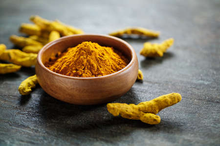 Turmeric in a bowl and curcuma root. Selective focus.の写真素材