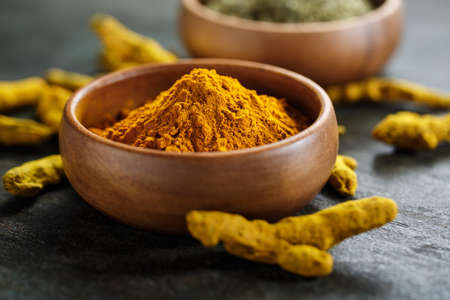 Turmeric in a bowl and curcuma root. Close-up.の写真素材