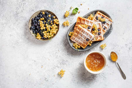 Belgian waffles with jam and berries. Top view. Delicious breakfast. Copy space.