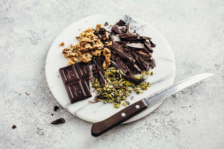 Ingredients for baking on a marble board. Dark chocolate, walnut and pumpkin seedsの写真素材