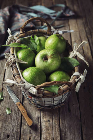 Fresh green apples in a basket, verticalの写真素材