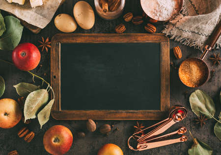 Empty chalkboard for writing message and ingredients for autumn baking, top view