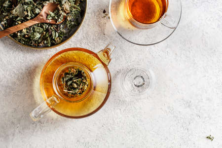 Glass teapot and a teacup with herbal tea.の写真素材