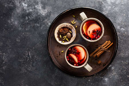 Mulled wine in big rustic mugs with spices and apple fruit.の写真素材