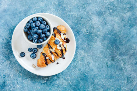 Croissant with chocolate and fresh blueberries.の写真素材
