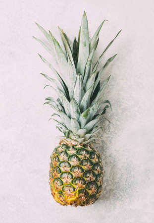 Ripe pineapple on grey textured backgroundの写真素材