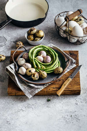 Ingredients for omelet or scrambled eggs, quail eggs, garlic, green beans.の写真素材