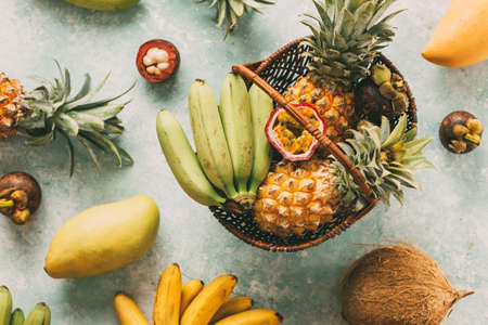 Ripe tropical fruits in a basket, pineapples, bananas, passion fruitの写真素材