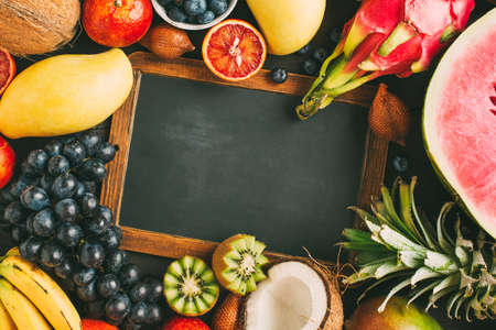 Exotic fruit and empty chalkboard with copy space. Top view. Thai fruits. Food background with copy space.の写真素材