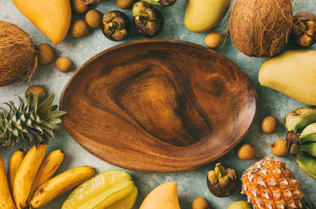 Summer tropical background with a space for a text, various fruits, bananas, pineapples, mango, coconut. Toned image, top view.の写真素材